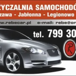 Wizytówka wypożyczalni samochodów RebeCar z Warszawy, Jabłonny i Legionowa. Srebrny Jaguar XF na czarno-pomarańczowym tle z danymi kontaktowymi.