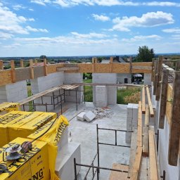 MAX-BUD - Wznoszenie ścian domu murowanego z bloczków Ytong w Trzebnicy, widok z góry na budowę w trakcie realizacji, z widocznymi materiałami budowlanymi i narzędziami.