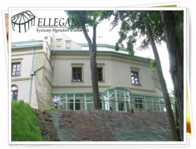 Elegancki budynek z przeszkloną werandą i zagospodarowanym terenem zielonym. Widoczne drzewa i logo firmy na budynku.