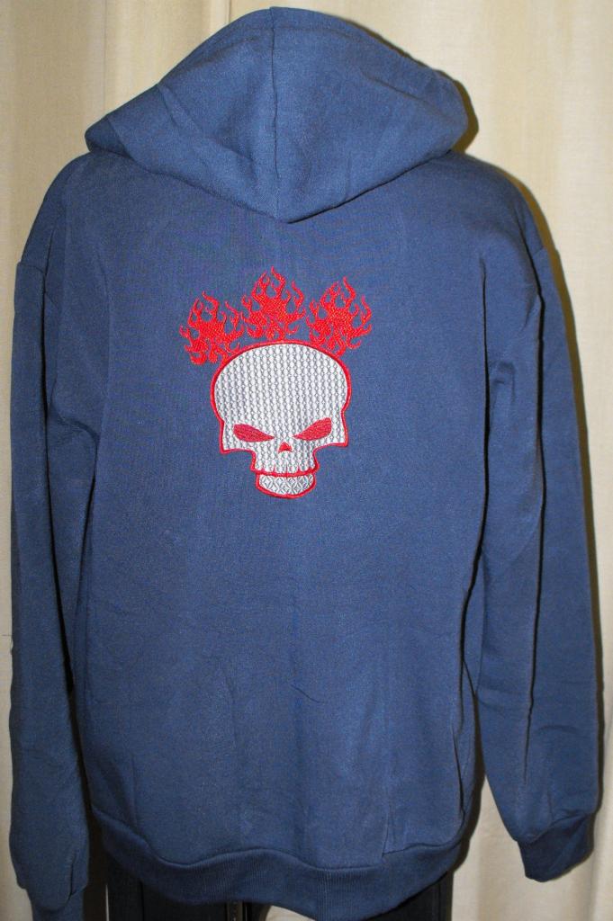 Granatowa bluza z kapturem, na plecach aplikacja: haftowany, szary czaszka z czerwonymi płomieniami. Widok z tyłu, na neutralnym tle.