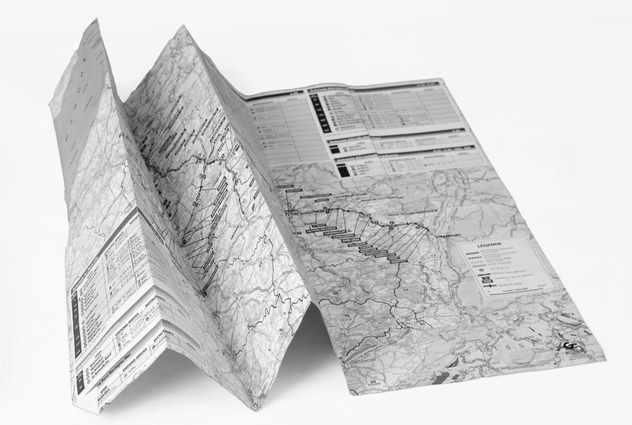 Rozłożona, składana mapa topograficzna w odcieniach szarości, ukazująca szczegółowy plan terenu z zaznaczonymi drogami, rzekami i punktami orientacyjnymi oraz tabelą z informacjami i legendą.