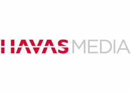 Logo Havas Media: czerwony napis 'HAVAS' z trójkątami zamiast 'A', obok szary napis 'MEDIA' na białym tle. Minimalistyczny design.