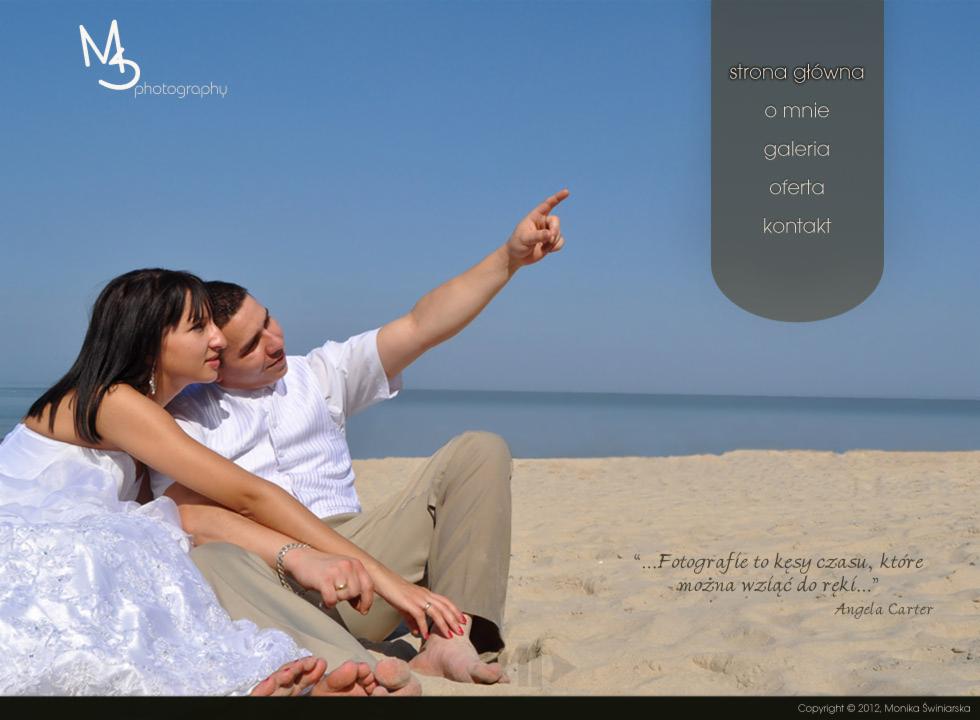 Para młoda siedzi na plaży, mężczyzna wskazuje palcem w górę, w tle morze i błękitne niebo. Widoczne menu strony internetowej fotografa.