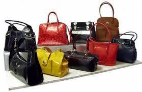 Kolekcja torebek używanych: czarne, czerwone, żółte, brązowe, lakierowane i matowe, różne fasony i rozmiary, na białym tle, ustawione na półce.