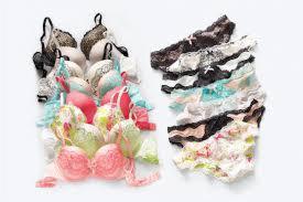 Zestaw bielizny damskiej: kolorowe biustonosze z koronką oraz majtki z różnorodnymi wzorami, ułożone na białym tle w estetycznej kompozycji.