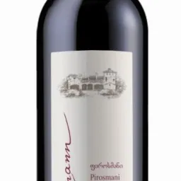 Butelka czerwonego, półsłodkiego wina Schuchmann Pirosmani z Gruzji, z etykietą w odcieniach bieli i beżu. Widoczny budynek na etykiecie. Pojemność 750 ml, 12,5% vol.