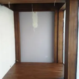 Drewniana konstrukcja antresoli z podłogą w Siedlcach, widoczne przewody elektryczne zwisające z sufitu.