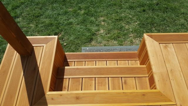 Schody zewnętrzne z drewna ryflowanego prowadzące do ogrodu, widok z góry, jasne drewno, precyzyjne wykończenie.