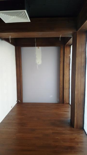 Drewniana konstrukcja antresoli z podłogą w Siedlcach, widoczne przewody elektryczne zwisające z sufitu.