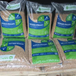 Sześć worków pelletu drzewnego Kawon na palecie, z widocznymi oznaczeniami jakości i certyfikatami. Worki z przezroczystego tworzywa z zielono-niebieskimi elementami graficznymi.