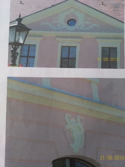 Fragment elewacji budynku z ozdobnymi elementami sztukaterii, widoczny lampion oświetleniowy i data 21/08/2010 w prawym dolnym rogu zdjęcia.