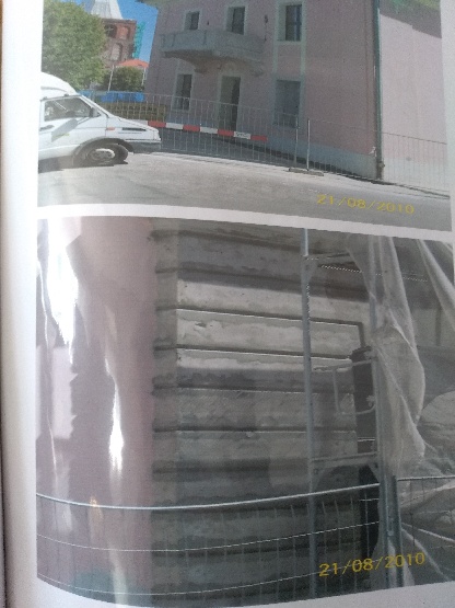 Fragment elewacji budynku w trakcie prac, widoczne rusztowania i zabezpieczenia, data na zdjęciu 21/08/2010.