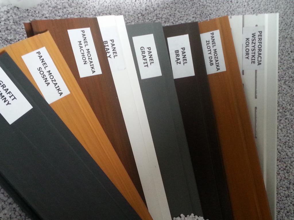 Przekrój paneli mozaikowych w różnych kolorach i wzorach, od grafitu po sosnę, prezentowanych na tle drobnego, szarego kruszywa.