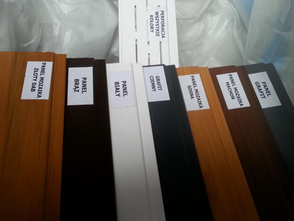 Próbki paneli wykończeniowych w różnych kolorach i wzorach: dąb, sosna, mahoń, grafit, biały, brąz. Prezentacja z perforacją.