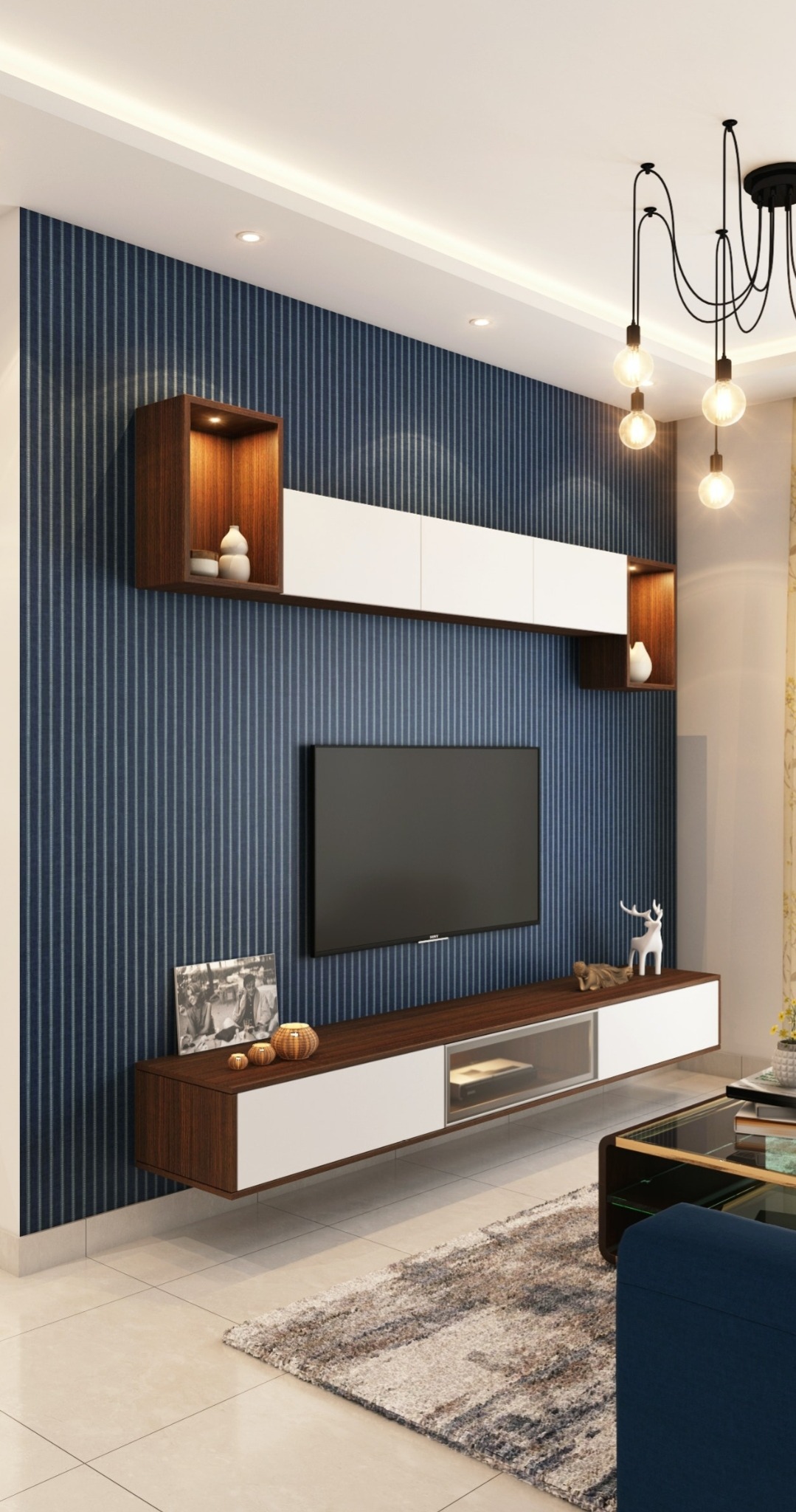 Nowoczesny salon z niebieską ścianą w pionowe paski, wiszącą szafką RTV z białymi frontami i drewnianymi elementami, oraz dekoracjami: ramka ze zdjęciem, ceramiczne figurki, szklany stolik kawowy...