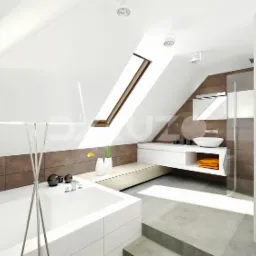 Jasna łazienka na poddaszu z oknem dachowym, białą wanną, umywalką nablatową i brązowymi płytkami ściennymi, oświetlona lampą podłogową o dużym białym kloszu.