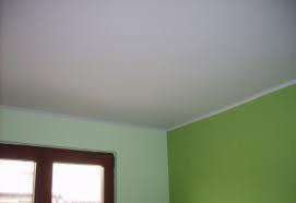 Ściana i sufit po malowaniu na zielono i biało. Widoczne listwy wykończeniowe przy suficie i framuga okna.