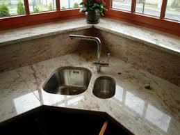 Marmurowy blat kuchenny ze zintegrowanym zlewem i ociekaczem, widok z góry, ciepłe oświetlenie, drewniana rama okienna w tle. Blat o nieregularnym kształcie.