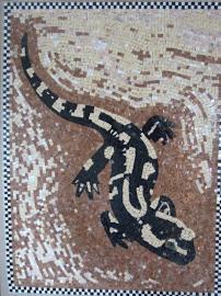 Mozaika ścienna przedstawiająca salamandrę w odcieniach brązu, beżu i czerni, otoczona ramą w szachownicę. Unikalny wzór z drobnych elementów.