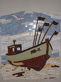 Mozaika ścienna przedstawiająca łódź rybacką z napisem 'MIE-11' na tle morza i plaży, wykonana z drobnych, różnokolorowych płytek. Unikatowa dekoracja wnętrza.