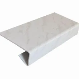 Biała nakładka parapetowa z wzorem marmuru, widoczna z perspektywy lekko z góry, ukazująca profil z zaokrąglonym brzegiem i podcięciem.