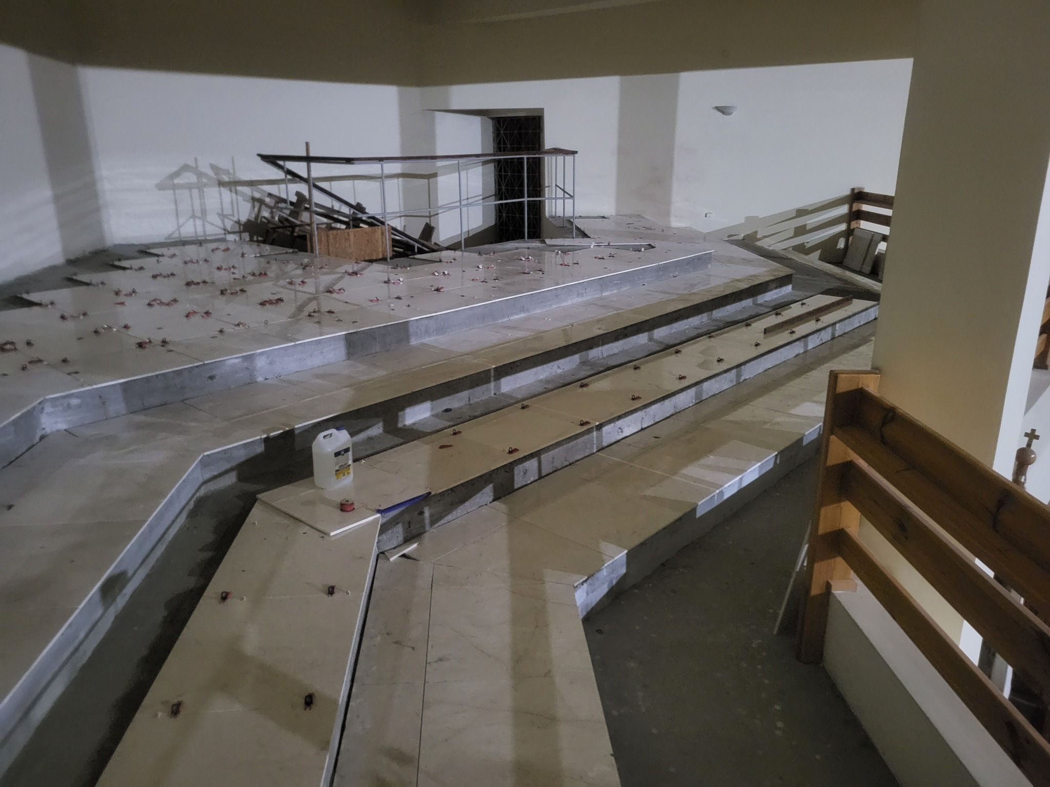 Wnętrze w trakcie prac wykończeniowych: ułożone płytki na schodach, widoczne narzędzia i materiały budowlane. Etap prac przed finalnym wykończeniem.