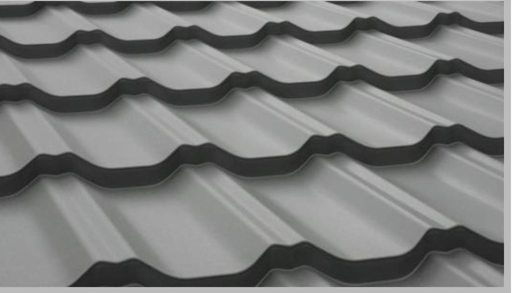 Szare metalowe elementy dachowe z wyraźnym wzorem falistym, ułożone w rzędach, widoczne z bliska pod kątem.