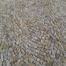 Granitowa kostka ułożona w okrągły wzór, z przewagą szarych i beżowych odcieni. Widok z góry, ukazujący regularność i precyzję ułożenia.