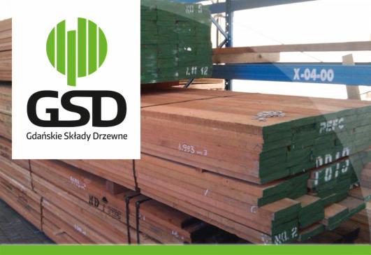 Stos tarcicy budowlanej z widocznym logo 'GSD Gdańskie Składy Drzewne' i oznaczeniami na krawędziach desek, umieszczony na regale w magazynie.