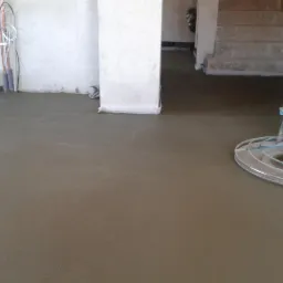 Wygładzona posadzka jastrychowa w Choszcznie, tuż po wylaniu i wstępnym wyrównaniu, z widoczną maszyną do zacierania, przygotowana do dalszej obróbki.