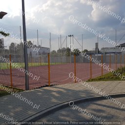 P.P.H.U. WAWMAR MAREK WAWRZONOWSKI - Ogrodzenie boiska sportowego z siatki i paneli, widok z chodnika z kostki brukowej, oświetlenie boiska.