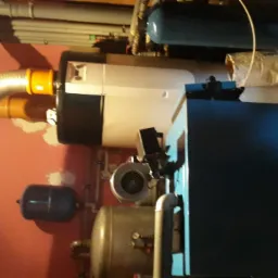 Ukończona instalacja pieca CO w kotłowni, widoczne rury, zbiorniki wyrównawcze i elementy podłączeniowe.