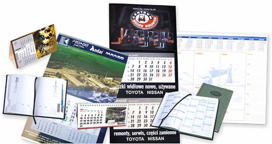 Różnorodne kalendarze firmowe: biurkowe, ścienne, książkowe, z logo firm i grafikami, prezentujące usługi i produkty. Wyeksponowane daty i nazwy marek.