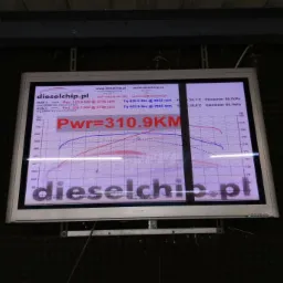 Ekran z wynikami pomiaru mocy i momentu obrotowego silnika BMW X5 3.0 CT po chip tuningu, prezentujący wykresy i dane z dwóch przebiegów testowych. Widoczny adres strony internetowej firmy tuningowej.