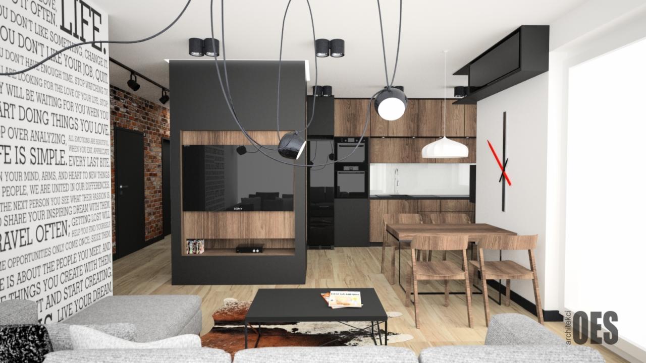 Nowoczesne wnętrze mieszkania z drewnianą zabudową kuchenną, szarą sofą i ścianą z napisem, oświetlone lampami wiszącymi i reflektorami.