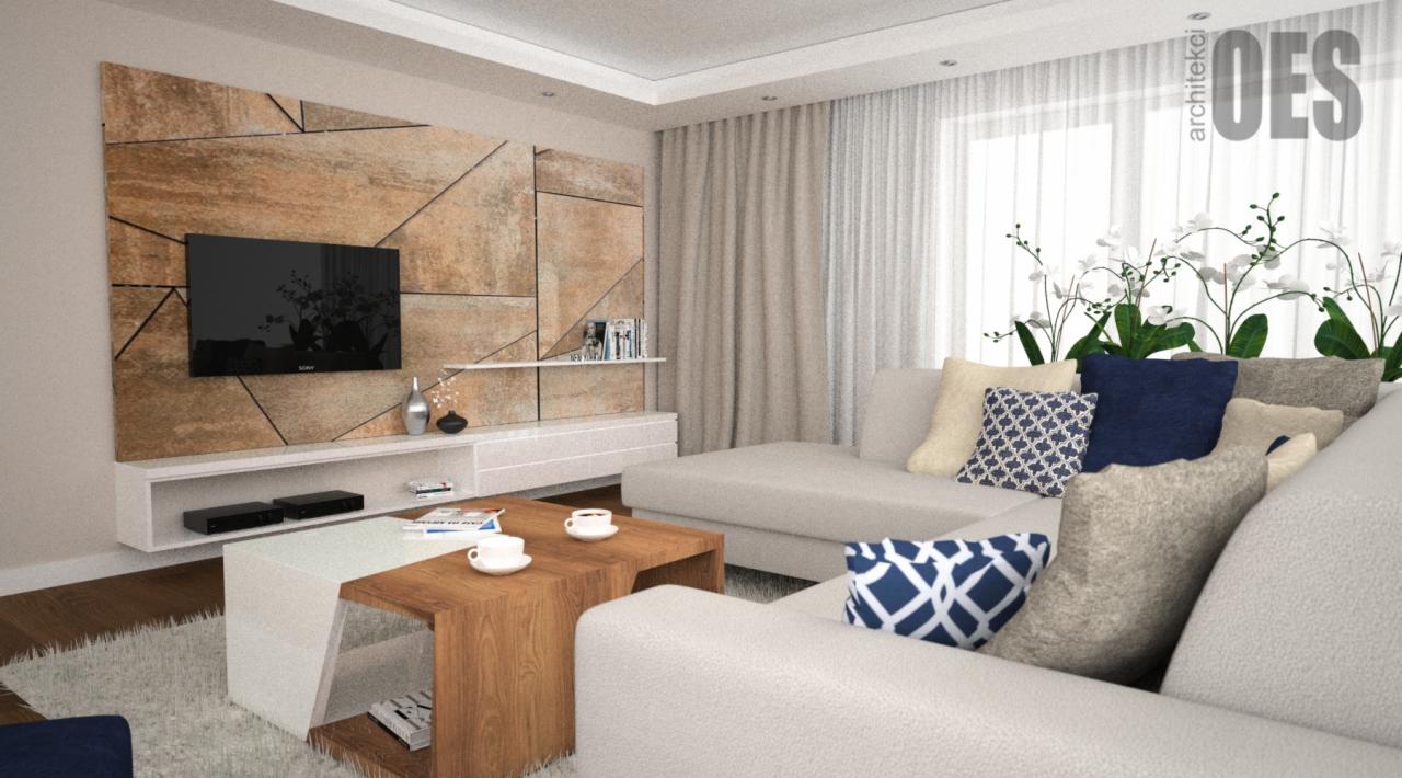 Nowoczesny salon z geometryczną ścianą z płytek imitujących kamień, telewizorem, białymi meblami, sofą z poduszkami w odcieniach beżu i granatu oraz stolikiem kawowym z filiżankami.