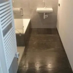 Wykończona łazienka w Przysusze z ciemną, polerowaną podłogą, białą umywalką wiszącą i grzejnikiem drabinkowym po lewej stronie.