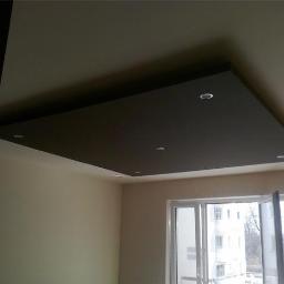 EKO-INSTAL PIOTR BAJOR - Podwieszany sufit w kolorze grafitowym z oświetleniem punktowym, widok z dołu. Nowoczesne wykończenie wnętrza z dużym oknem balkonowym.