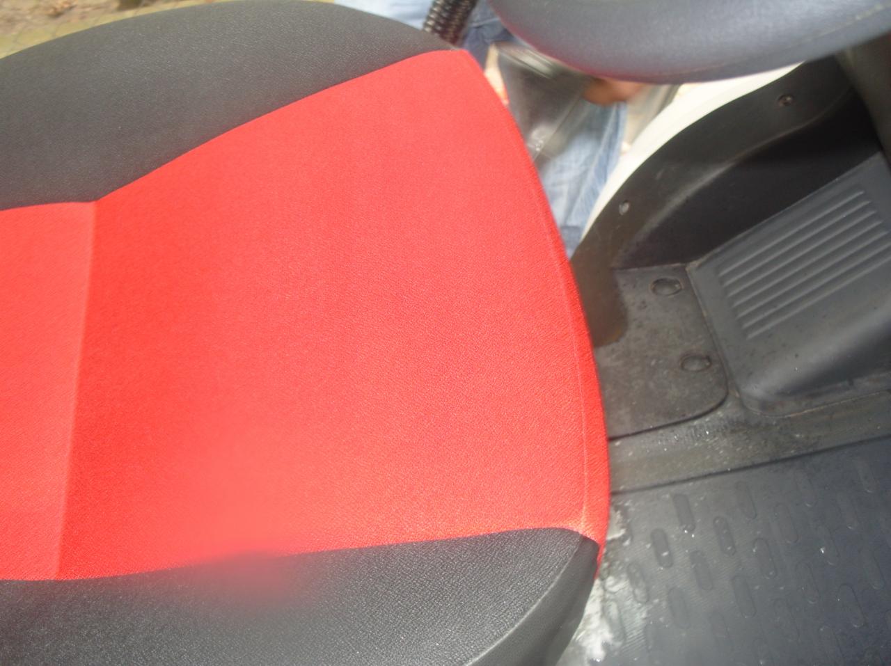 Czerwono-czarne tapicerowane siedzenie samochodowe po czyszczeniu w Warszawie, widoczne detale faktury materiału i czysta powierzchnia.