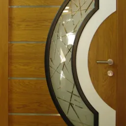 Drewniane drzwi z półokrągłym, matowym szkłem z abstrakcyjnym wzorem i srebrnymi akcentami, nowoczesny design.