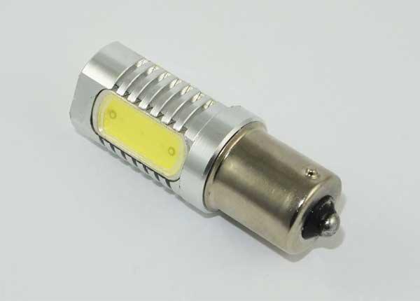 Żarówka samochodowa LED z aluminiową obudową i żółtym panelem świetlnym, widok z bliska na białym tle.