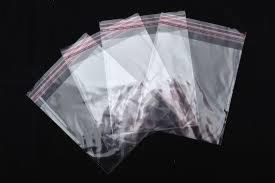 Przezroczyste worki PP z czerwoną taśmą strunową, ułożone warstwami na czarnym tle, widoczne z bliska.