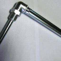 UNIMET Zakład Obróbki Metali - Metalowa oprawa do termometru szklanego, z gwintowanym mocowaniem i otworem na termometr, leżąca na białym tle.