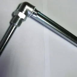 Metalowa oprawa do termometru szklanego, z gwintowanym mocowaniem i otworem na termometr, leżąca na białym tle.