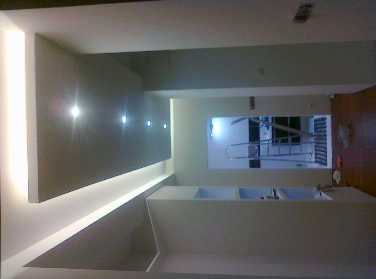 Nowoczesne wykończenie wnętrza z podwieszanym sufitem, oświetleniem LED i szarą ścianą akcentującą. Widoczny fragment drabiny.