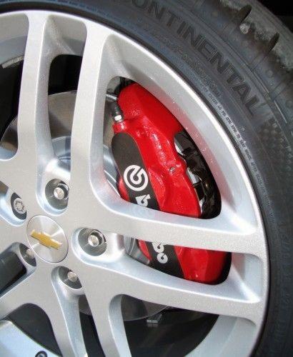Felga aluminiowa Chevrolet z czerwonym zaciskiem hamulcowym Brembo i oponą Continental, widok z bliska, detale tarczy i logo producenta.
