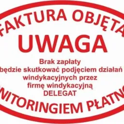Owalna, czerwona naklejka z napisem 'FAKTURA OBJĘTA UWAGA Brak zapłaty będzie skutkować podjęciem działań windykacyjnych przez firmę windykacyjną DELEGAT MONITORINGIEM PŁATNOŚCI'