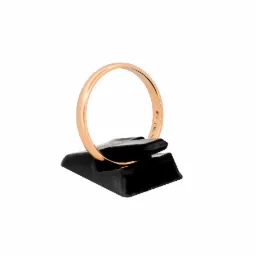 Złoty pierścionek próby Au 585 na czarnym, błyszczącym stojaku na białym tle.