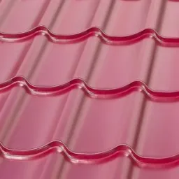 Błyszczące, różowe blachodachówki w kształcie fali, ułożone rzędami, z widocznymi refleksami światła.