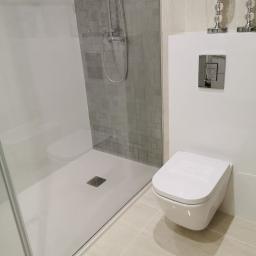 Fom-artdeconstruire-Adam Blachewicz - Nowoczesna łazienka z kabiną prysznicową typu walk-in, podwieszaną toaletą i dekoracyjnymi świecznikami na ścianie.